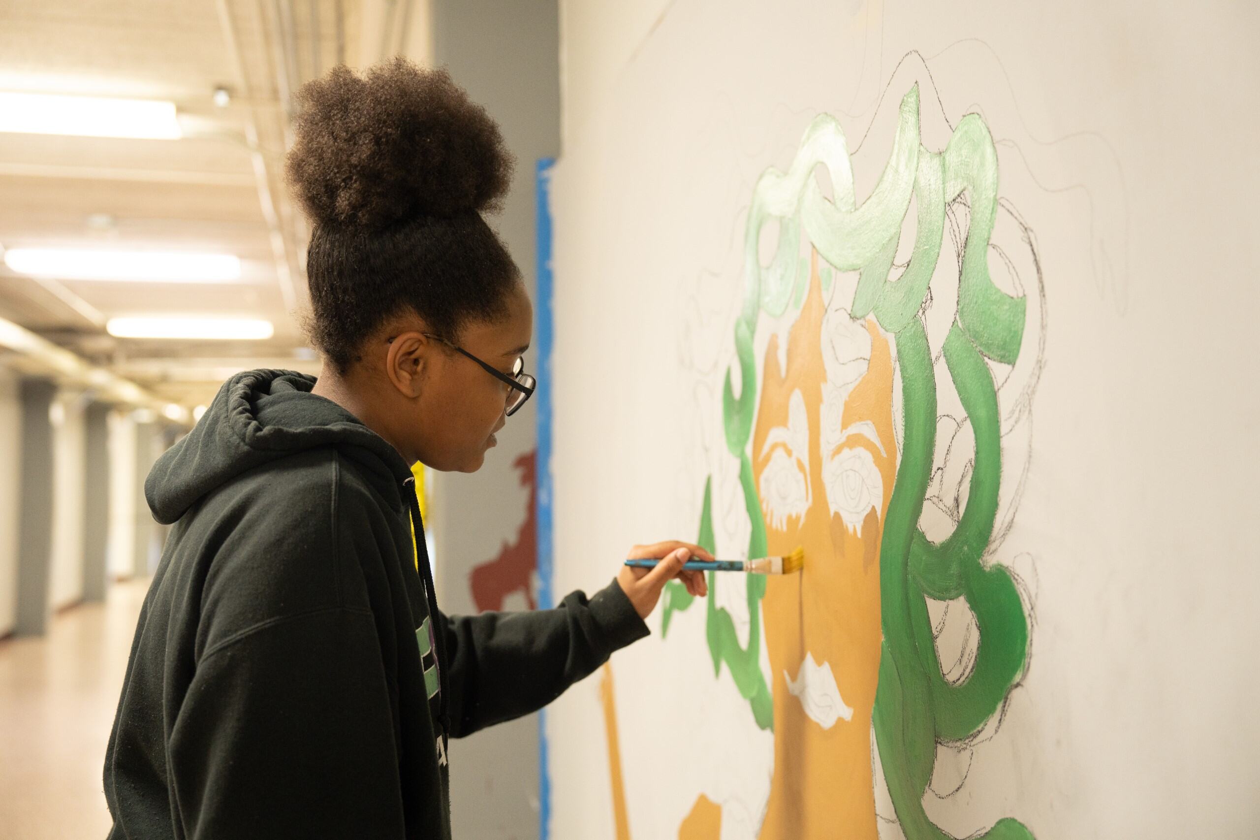 Student painting a mural