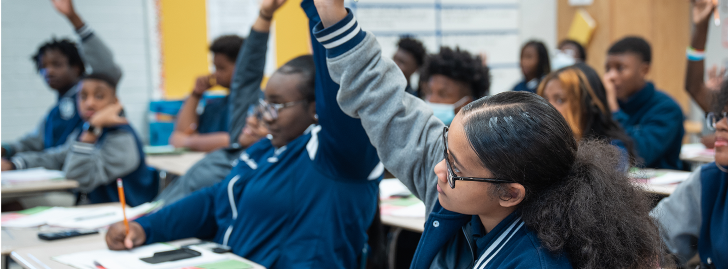 students in class raising their hands