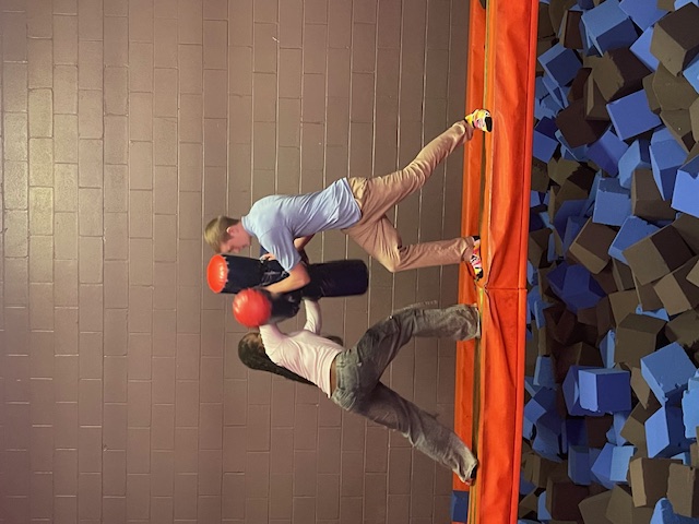 Two people, a man and a woman, engage in exercise with boxing equipment on an elevated surface.