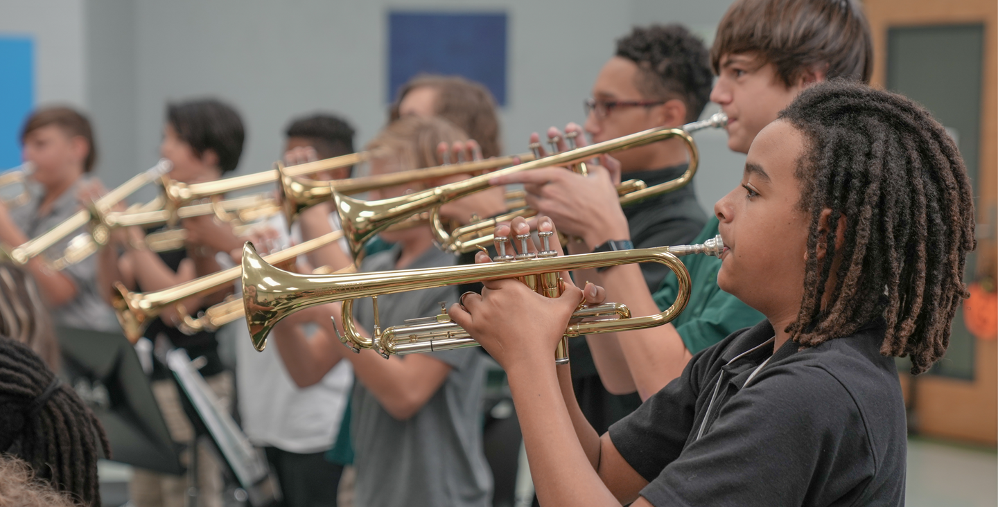 students playing trumpet in band class