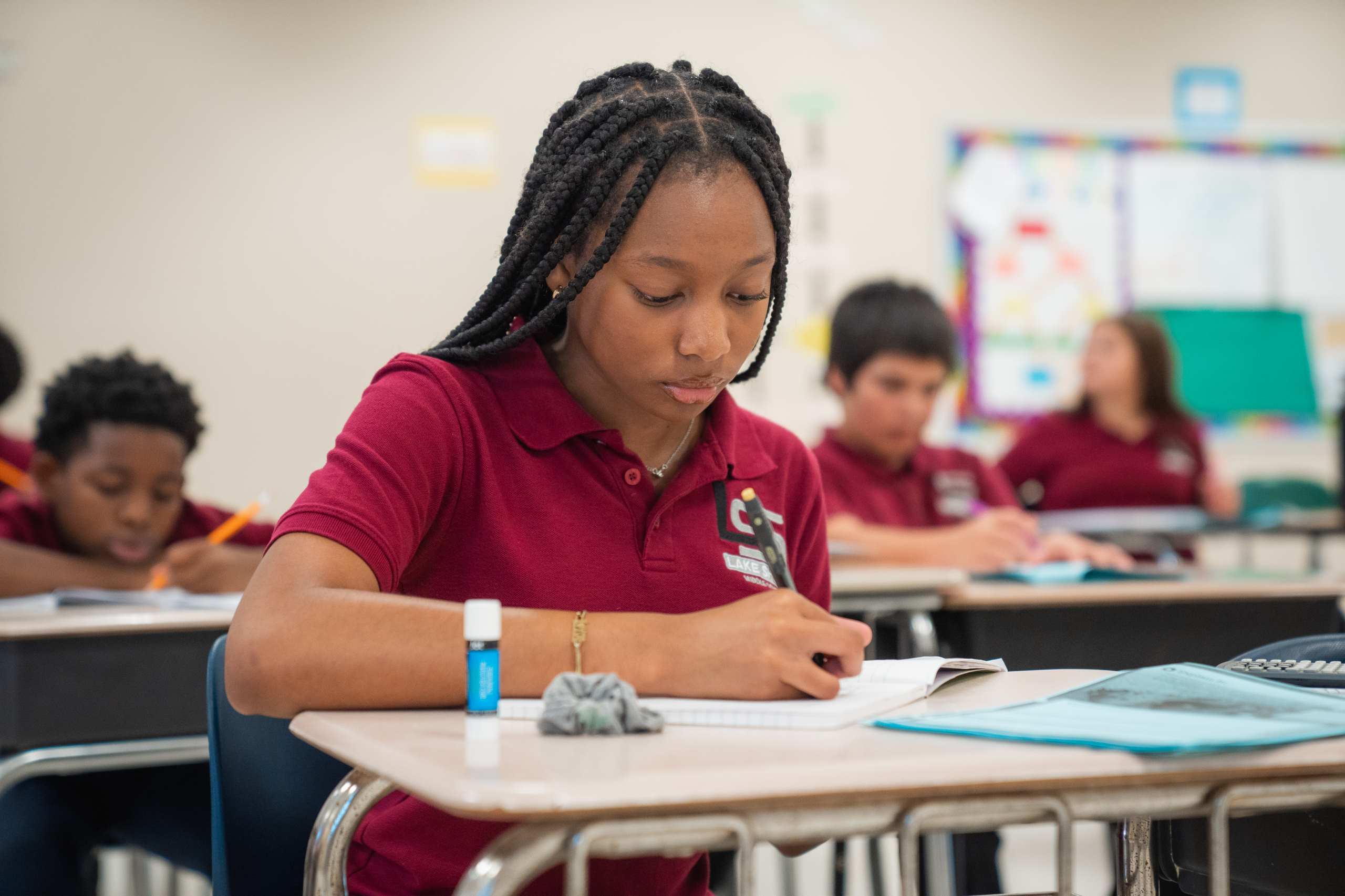 Student in uniform polo working on an assignment