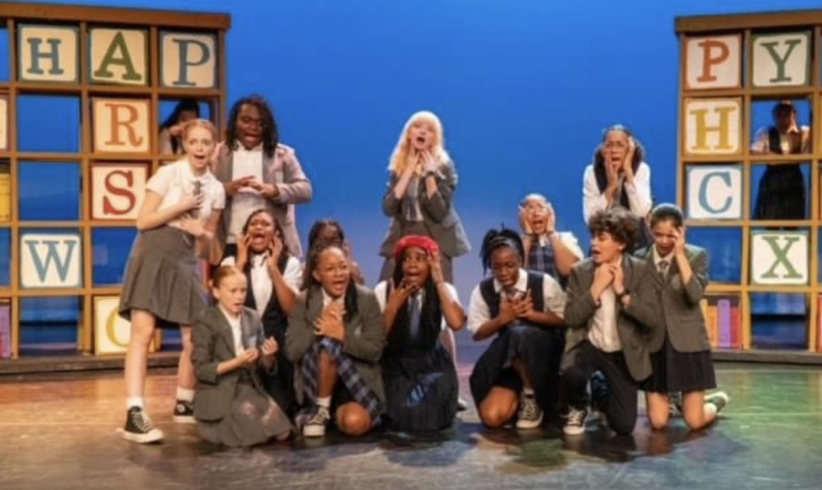 Group of actors on stage posing 