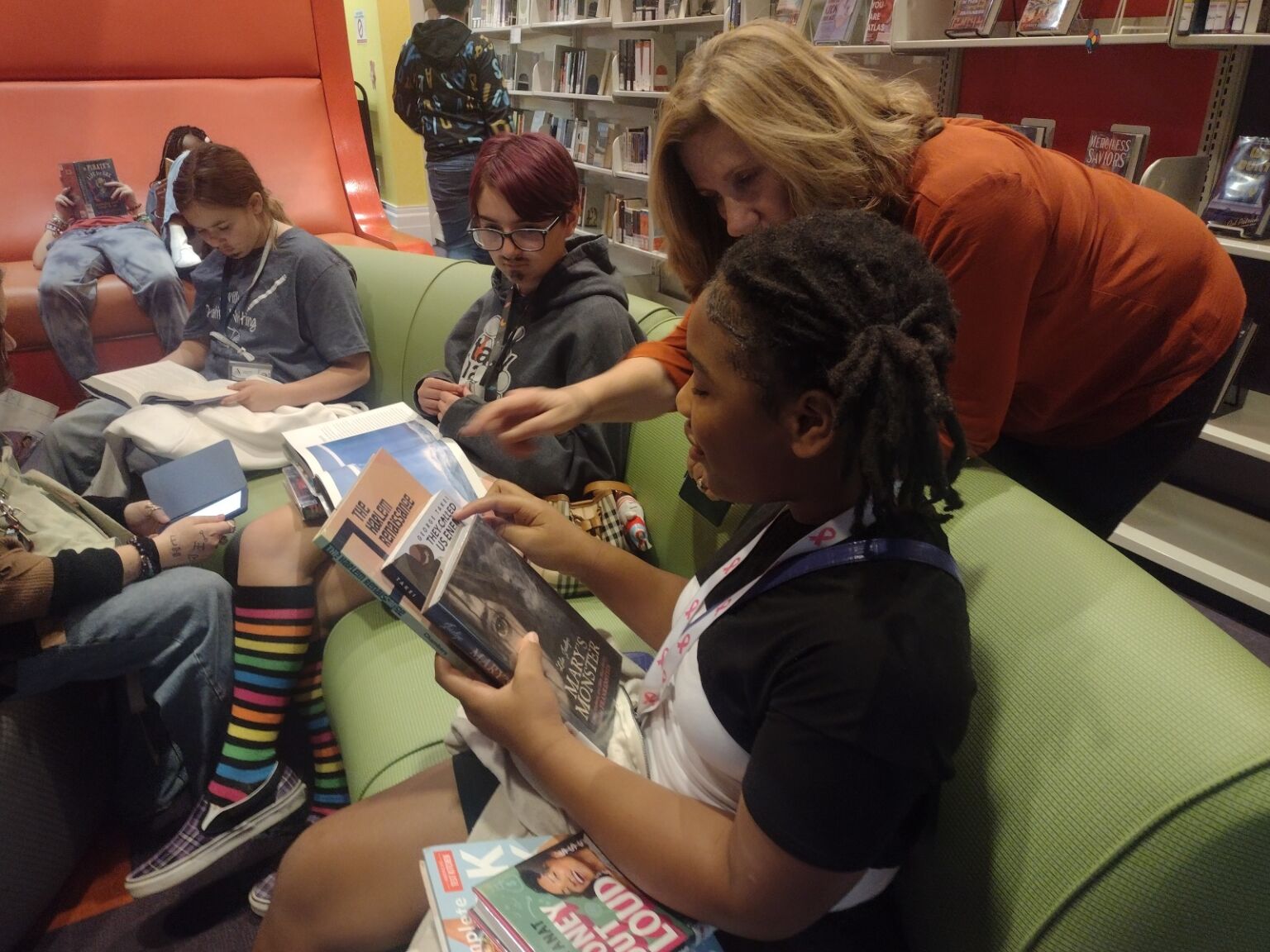 Students and teacher in library working together