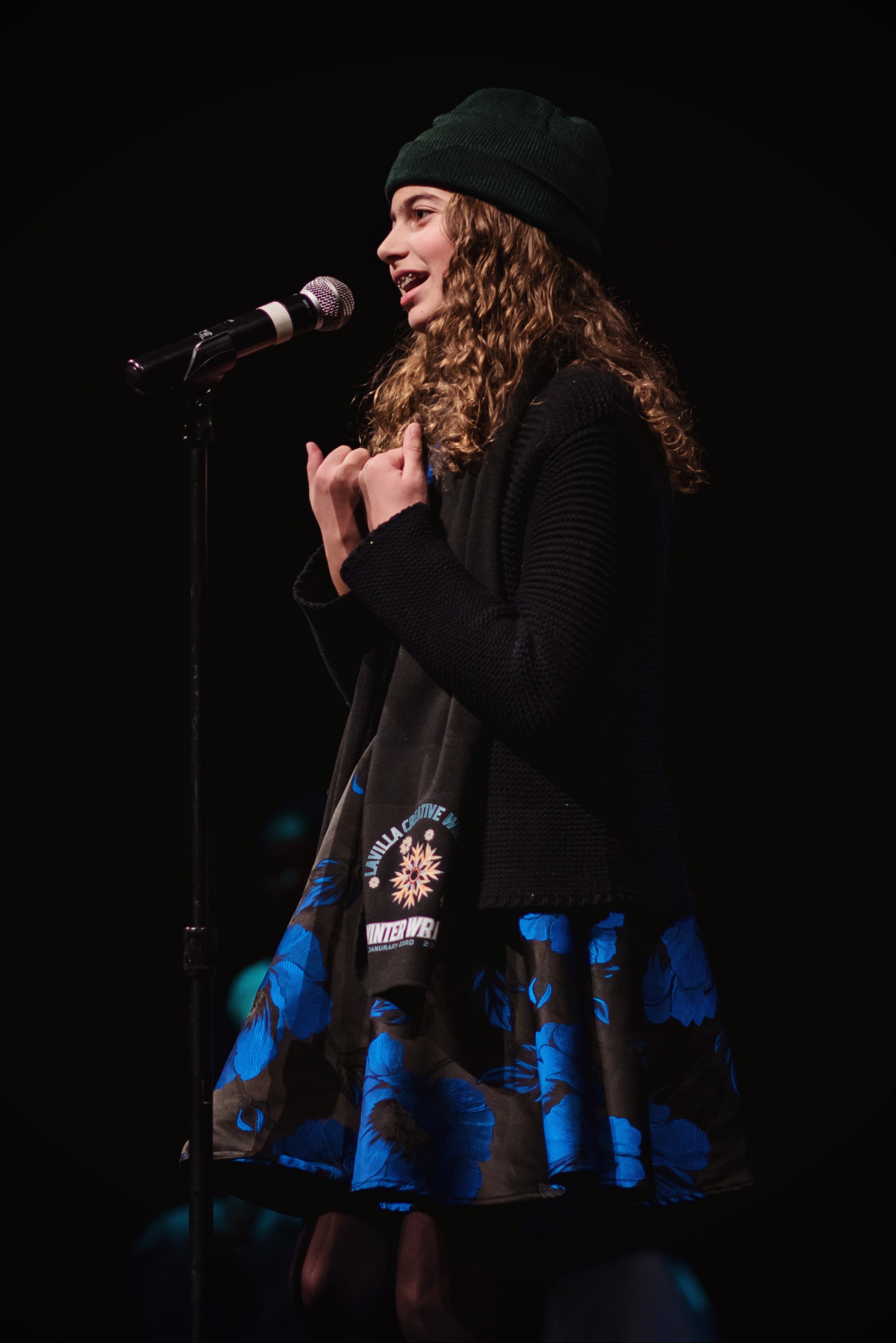 Student performing written work on stage