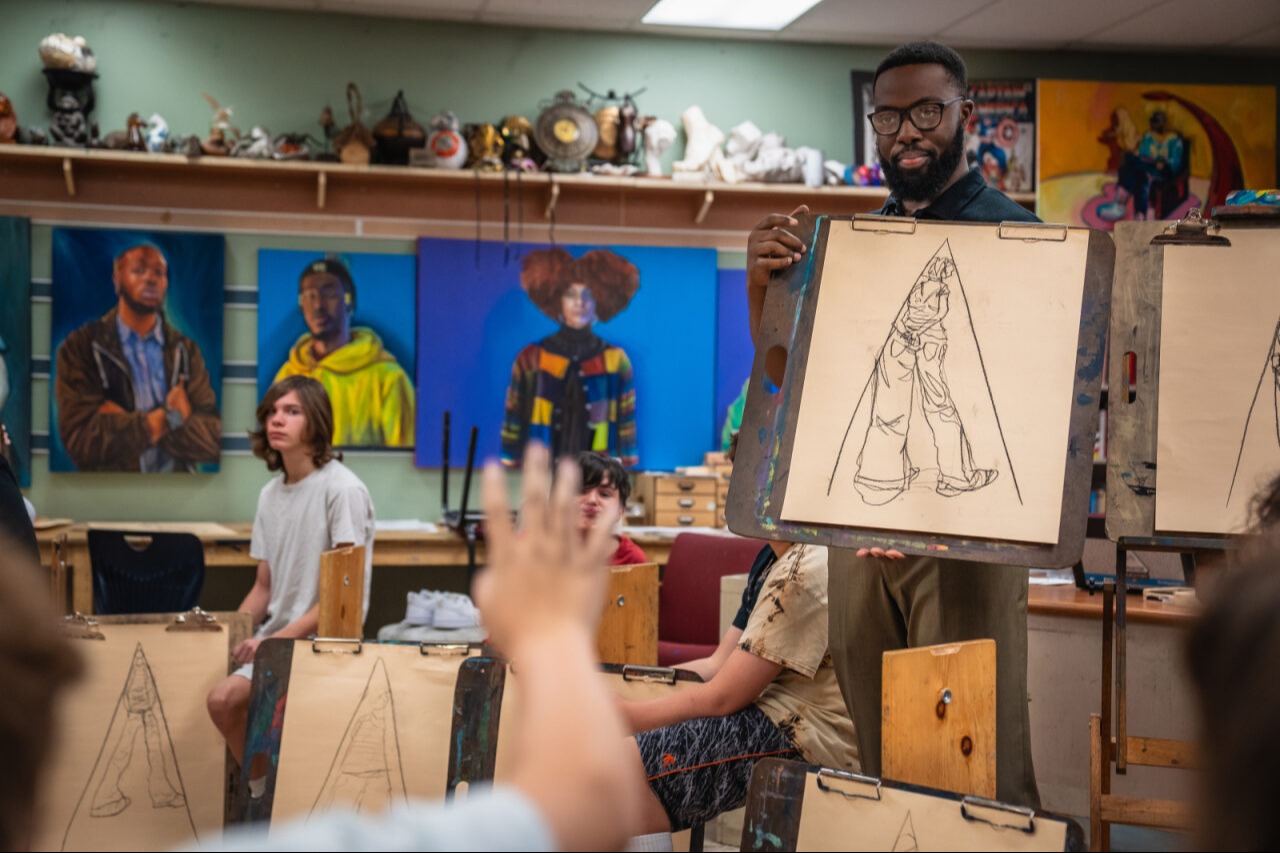 Art Class, teacher holding up an art piece