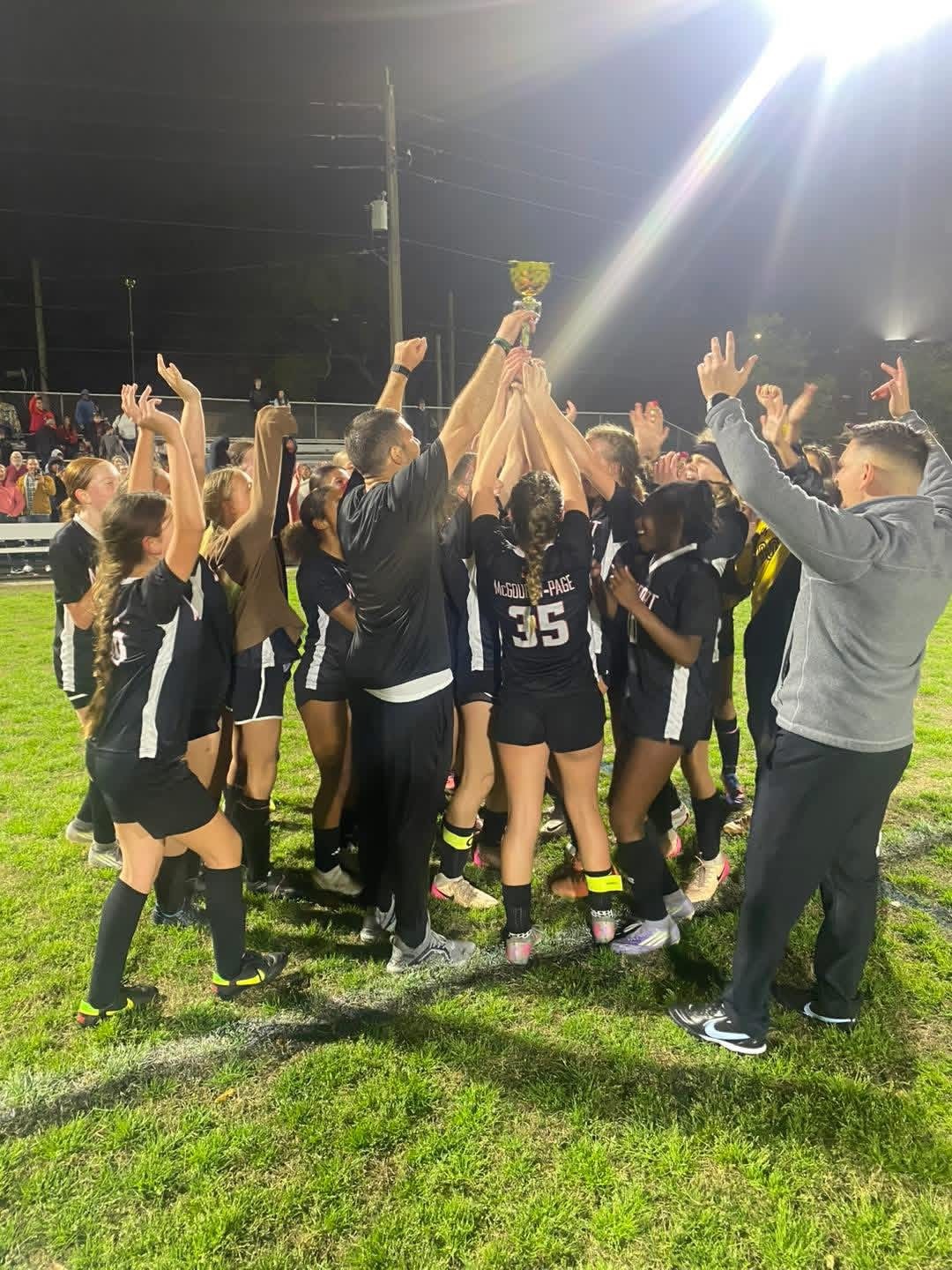 Female soccer players holding a trophy