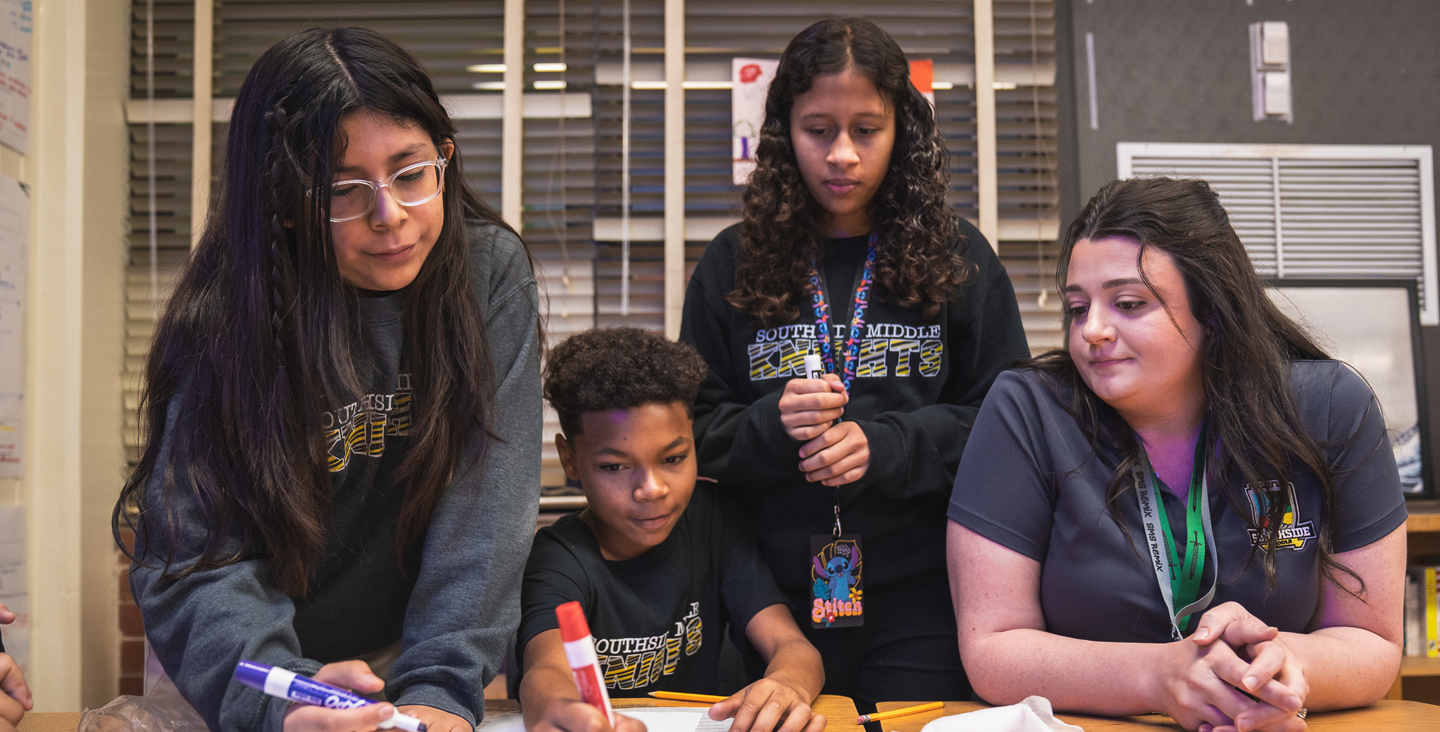 kids working together with the teacher on an activity