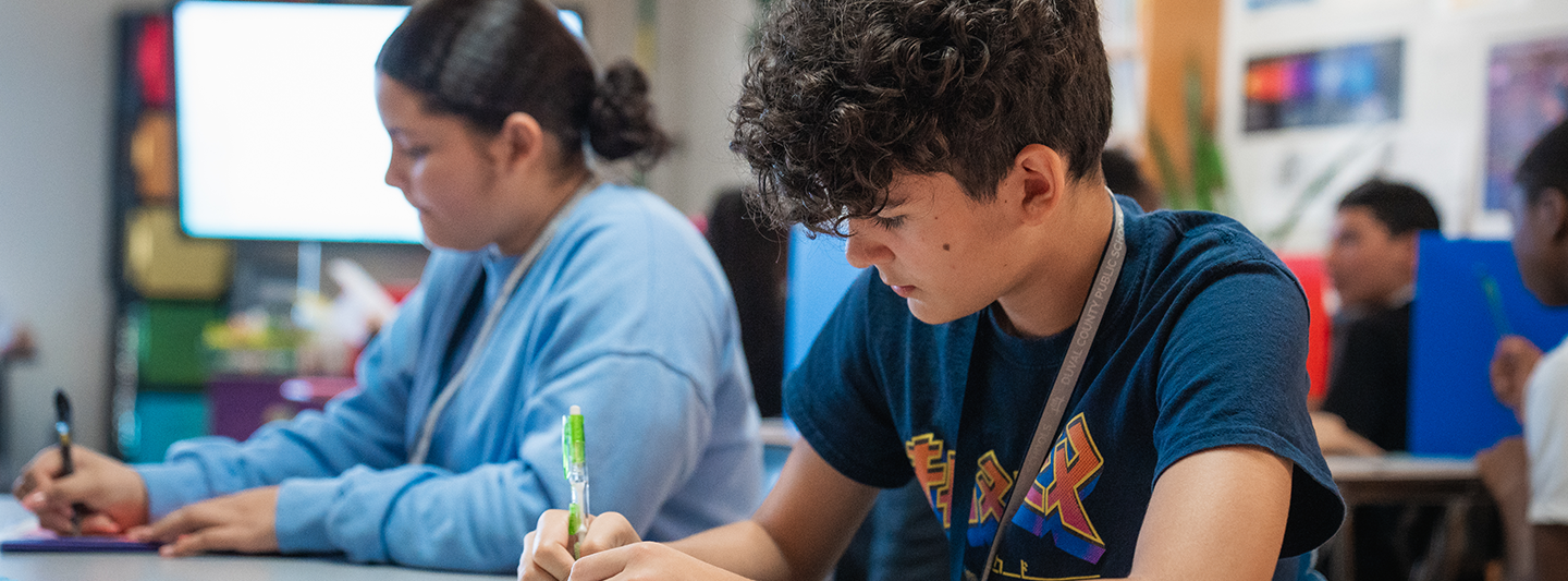 two students working at a table in a classroom