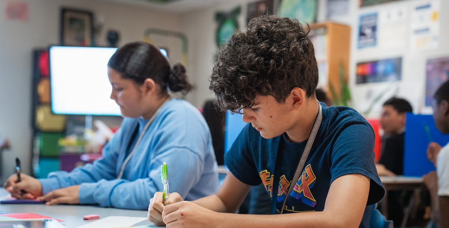 two students working at a table in a classroom