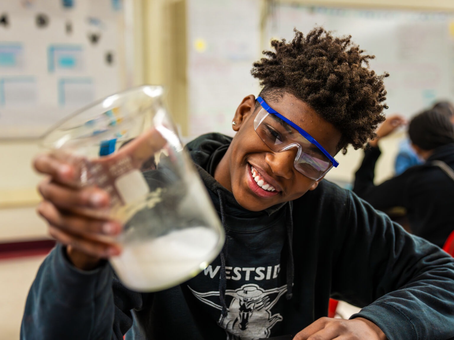 Student smiling at a science beaker