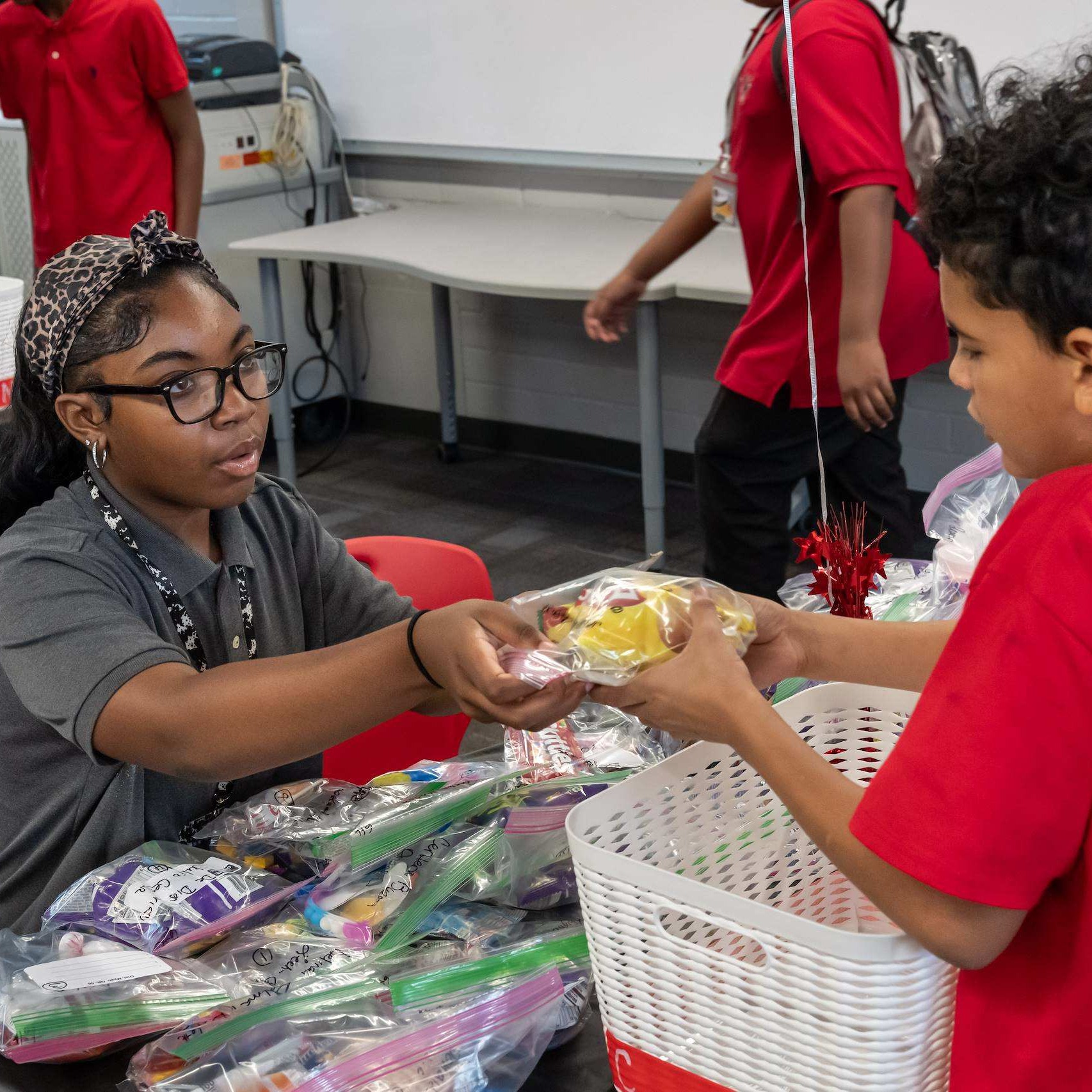 a student leader handing a 6th grader an award