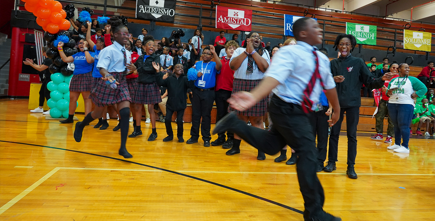 young men and women standing in a circle on a basketball court 