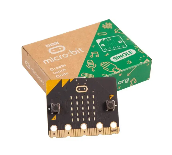 A black and yellow electronic board sits in front of a green and brown package. The package reads "micro:bit Create Learn Code" in white.