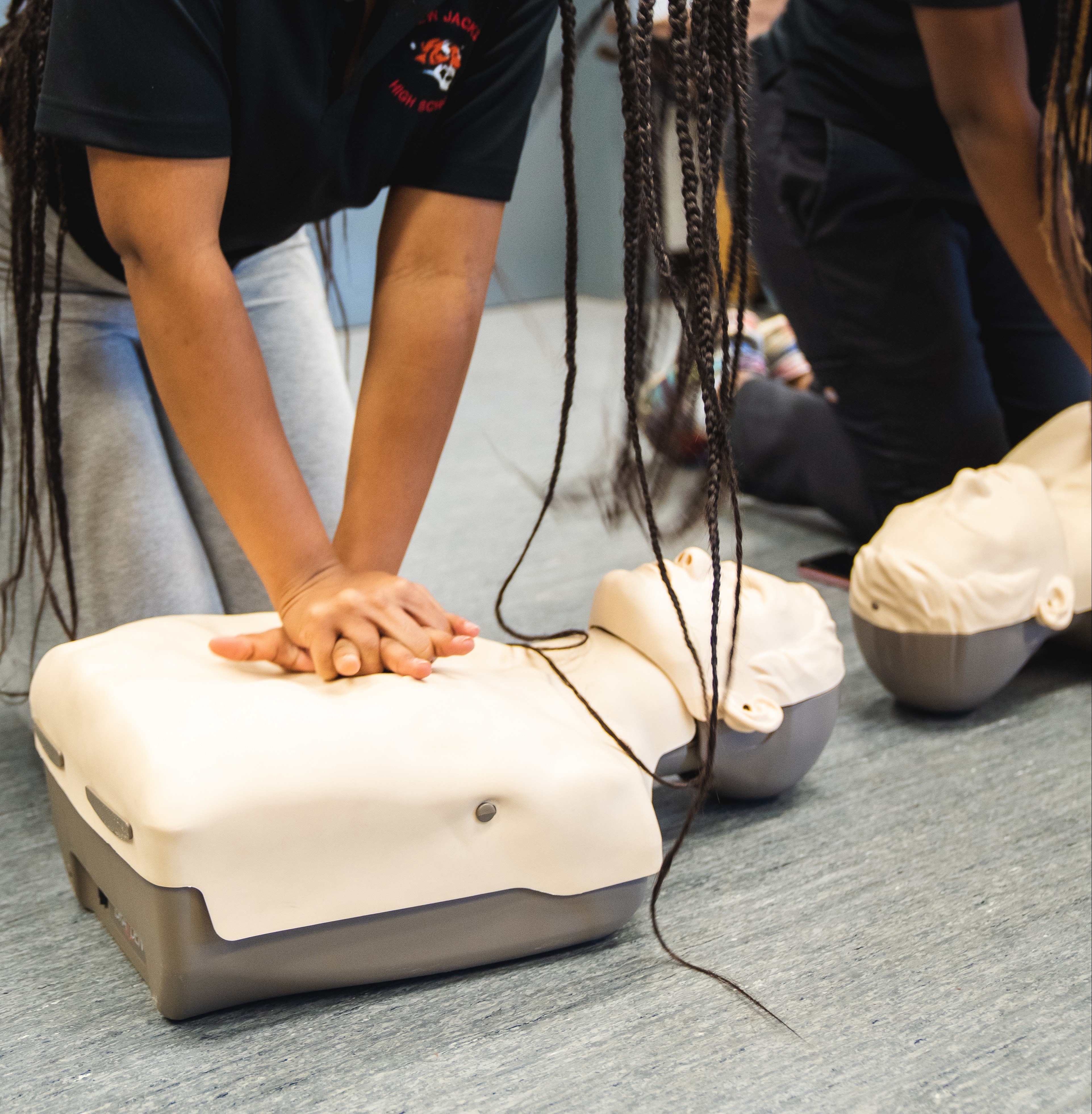 Detail of a female student practicing CPR