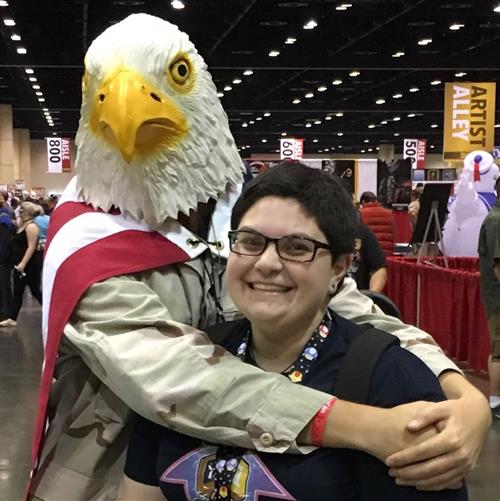 Students hugging while one of them is wearing an eagle mask