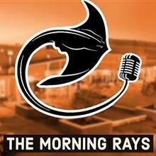 Orange tint background with image of the school. A black and white stingray with microphone on tail sits on top of the background. Across the bottom are the words The Morning Rays.