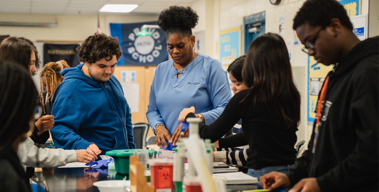 Students working with their teacher in a science lab