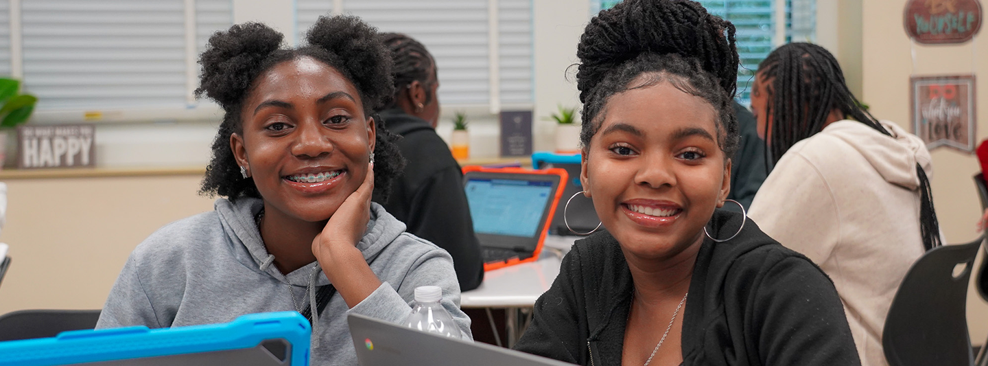 Two students smiling in class