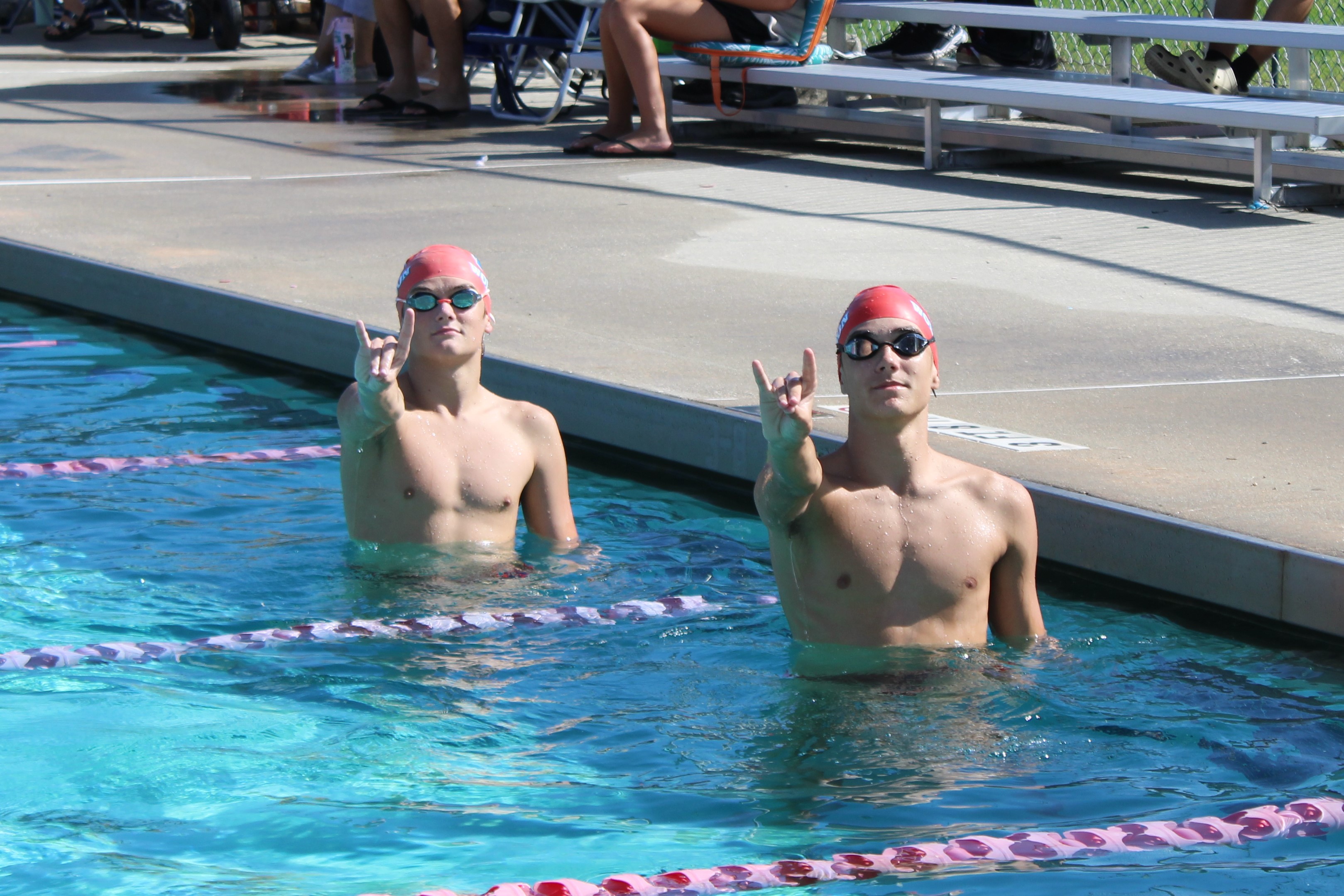 swimmers doing go pack sign