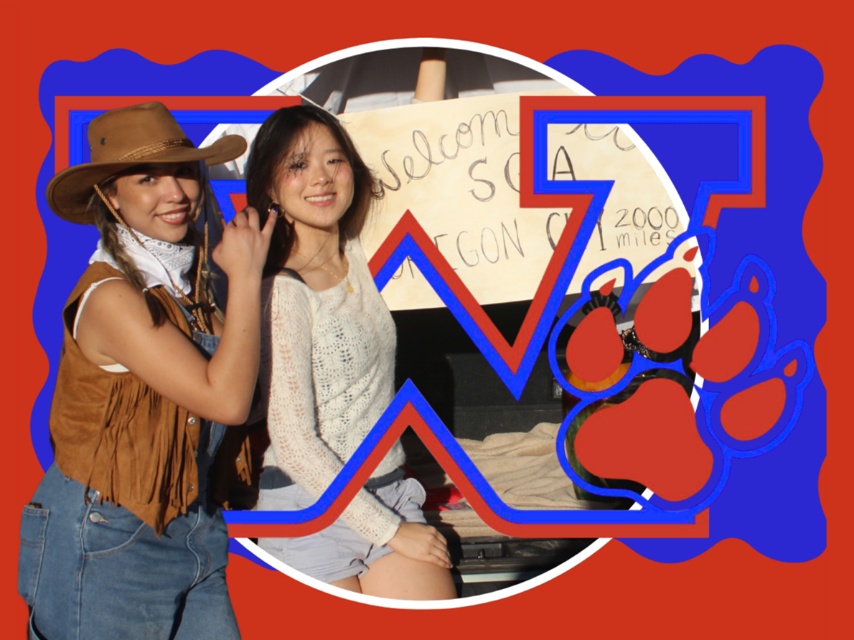 Two women pose behind a blue 'W' and a paw print. One wears a hat and vest; the other wears a white top.