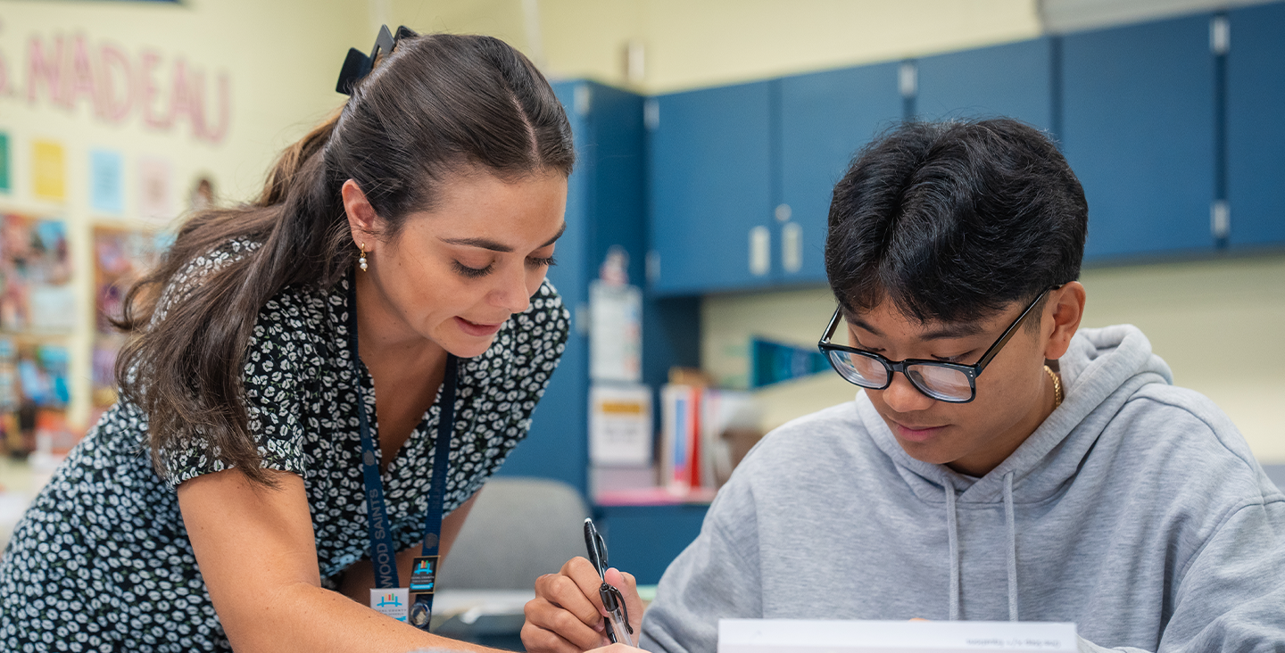 teacher working with student in classroom