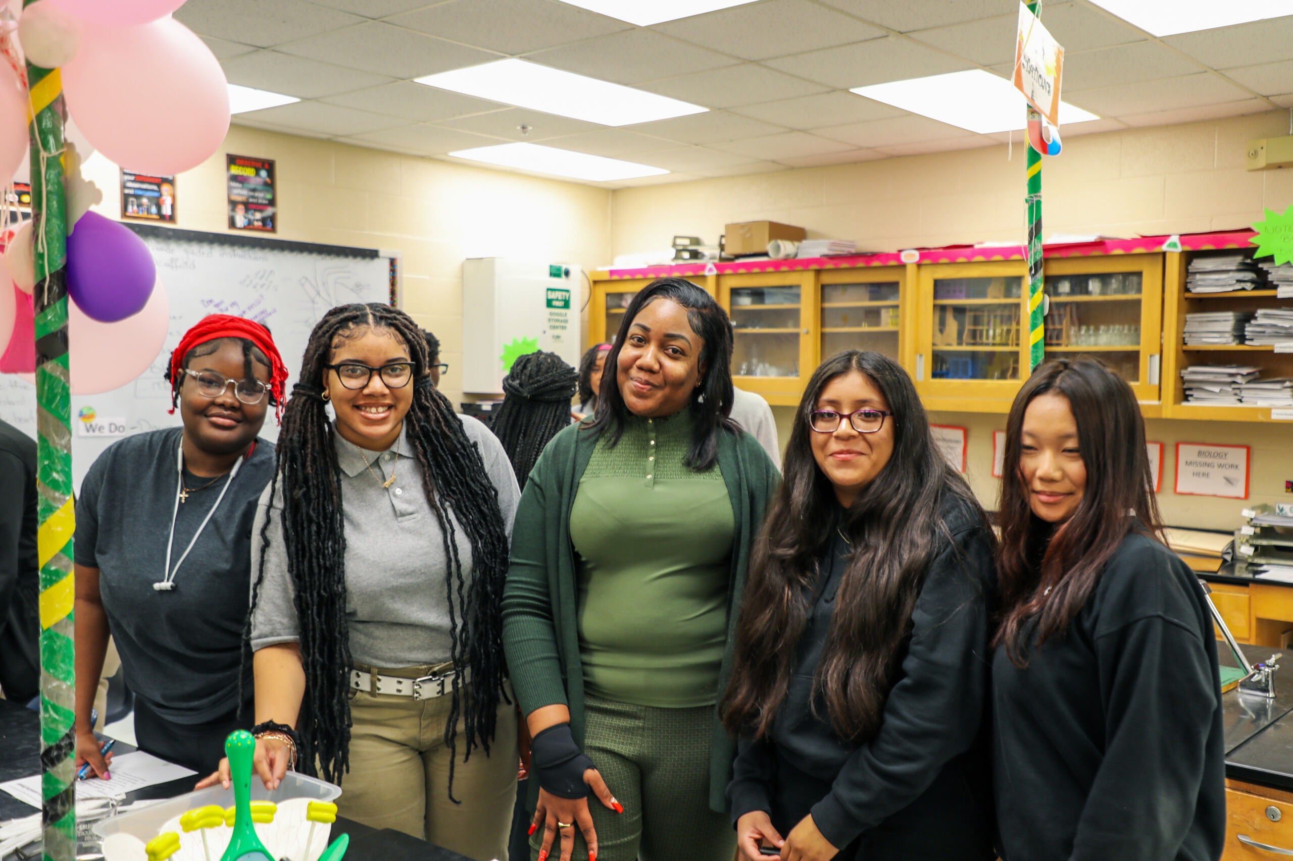 Five girls standing in class together smiling