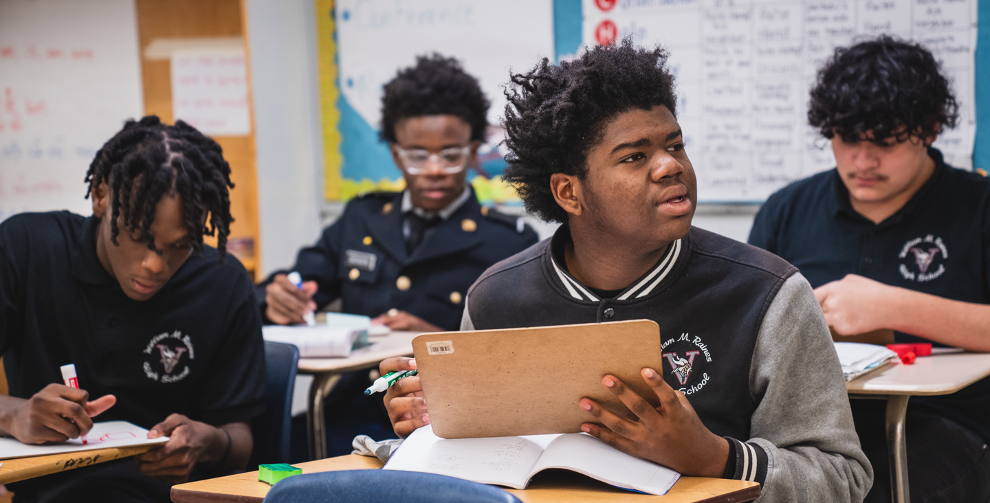 student asking a question about assignment while others work at their desks