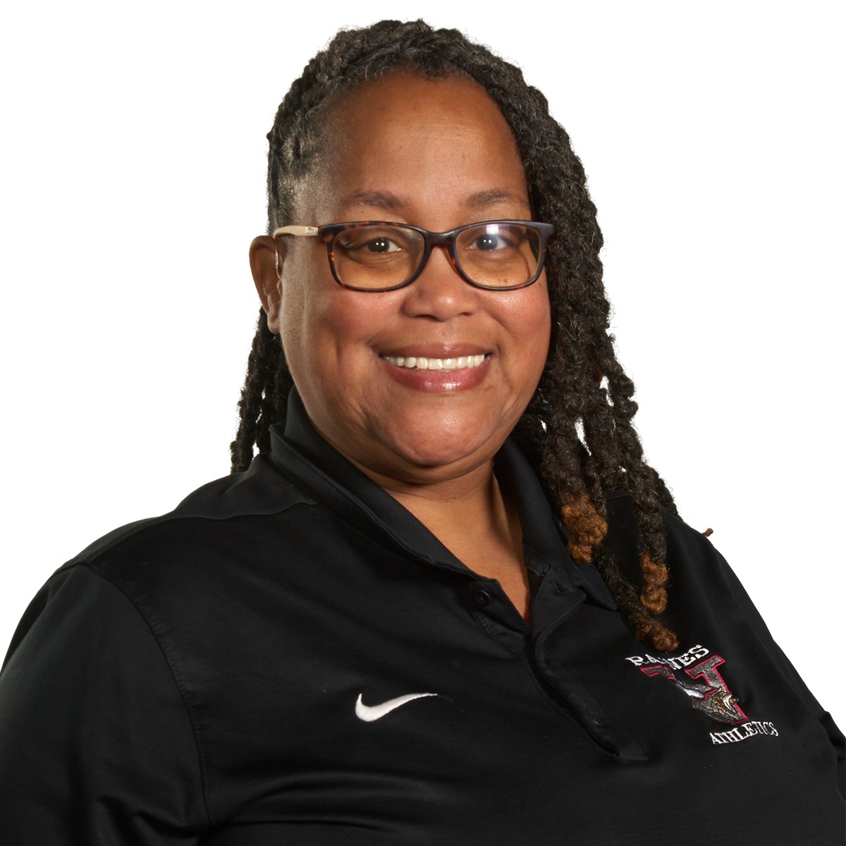A woman with curly hair and glasses smiles at the camera. She wears a black polo shirt with a white Nike logo.