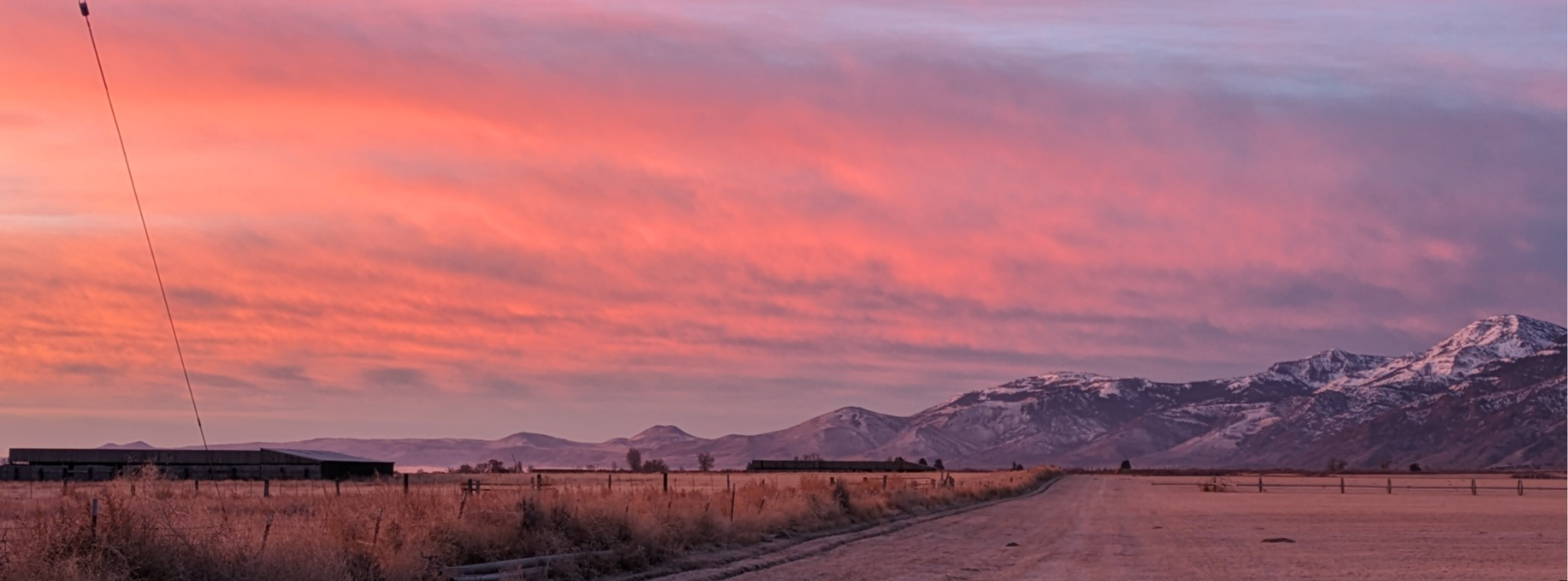 red sunset against snow capped mountains