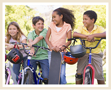 4 kids lean against their bicycles