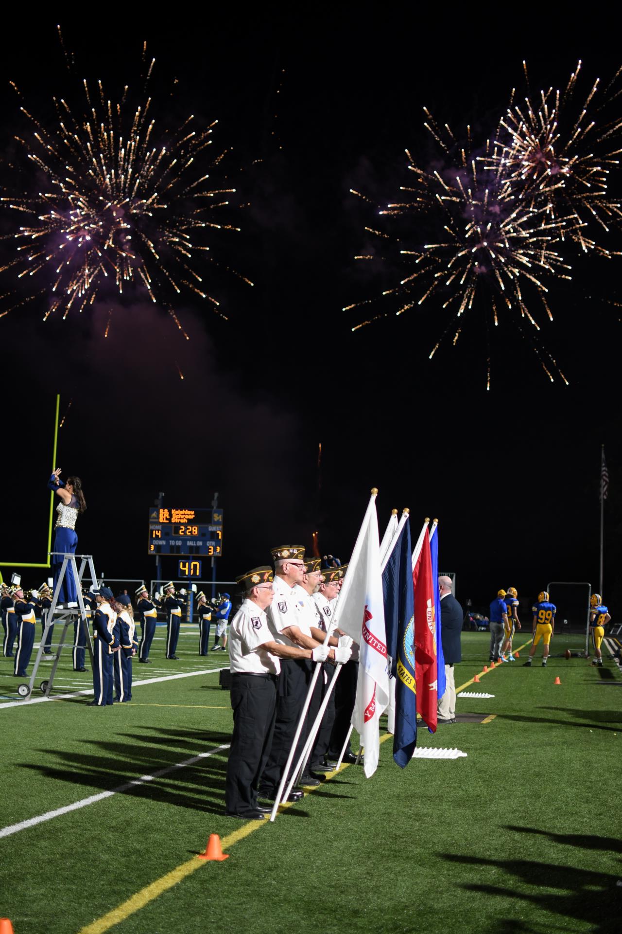 football game military members with fireworks