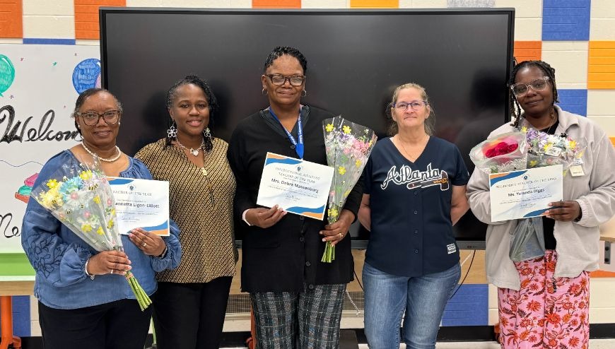 five women smiling with certificates and flowers