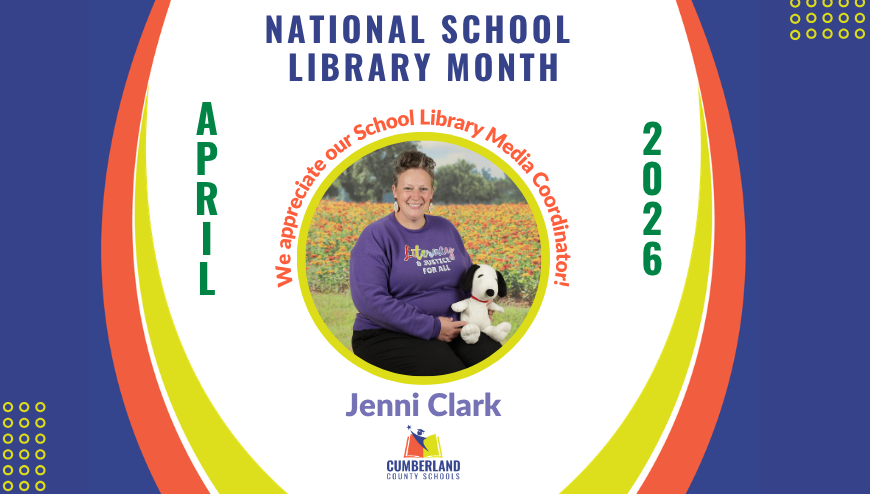 smiling woman holding Snoopy in front of a field of flowers