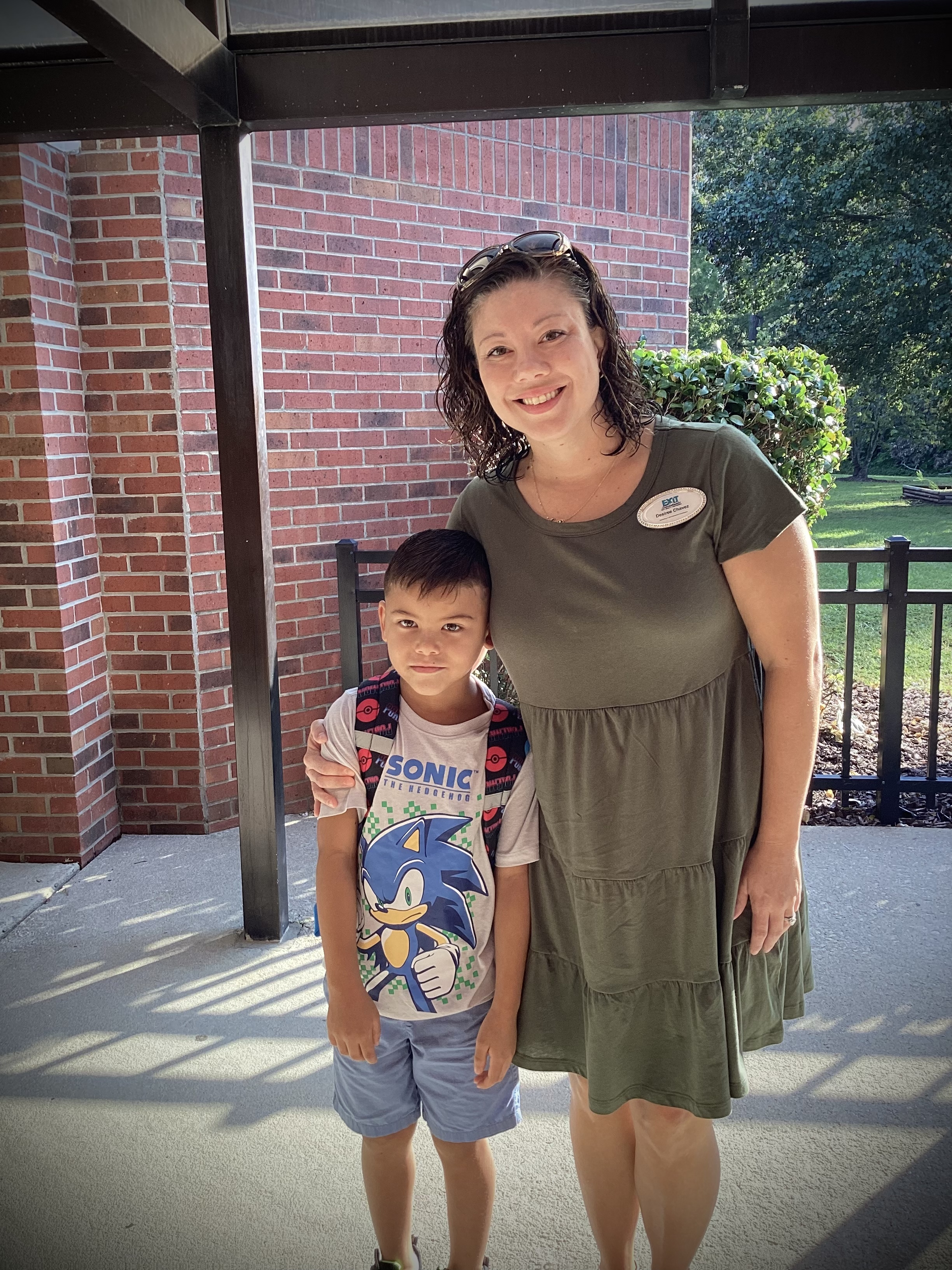 image of parent and child standing near school