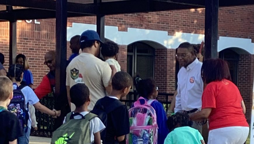 Image of parents and students waiting to enter the school.