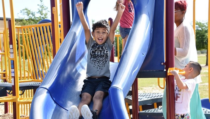 Image of a boy on a playground slide