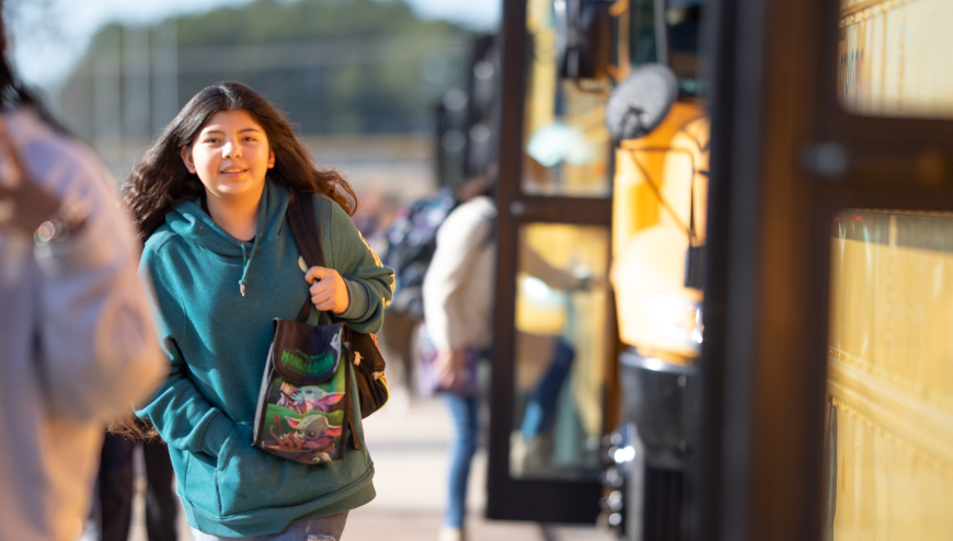 image of students walking by buses 