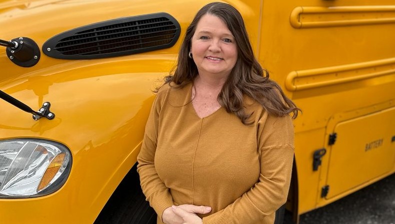 Bus driver in front of bus