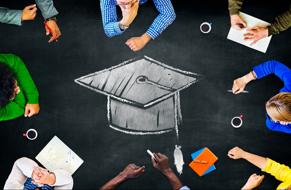 people sitting around grad cap holding chalk