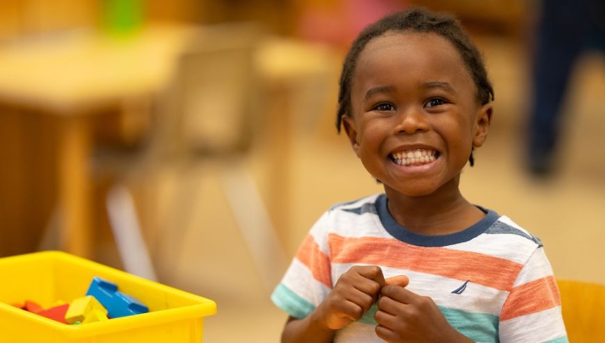 boy smiling playing blocks
