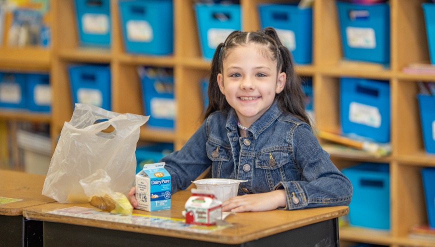 Student eating breakfast at desk