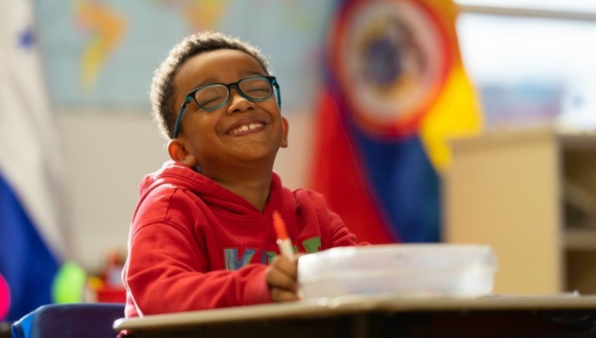 image of student at desk smiling