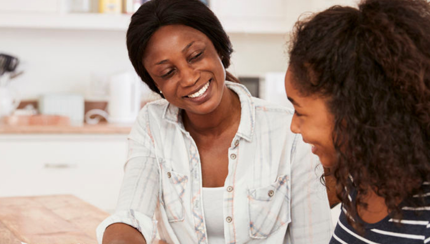 Adult woman smiling at young child