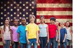 kids smiling and the american flag in the background