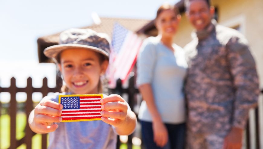 Military family with child holding a flag patch