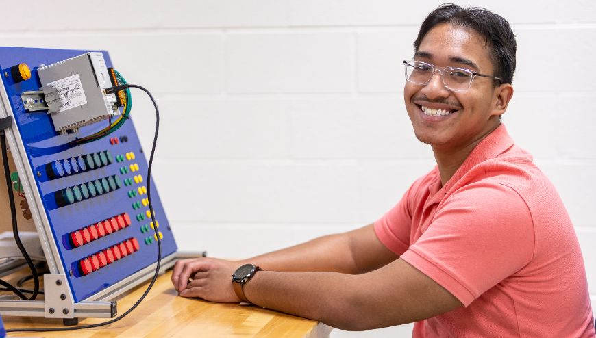 Image of Man with Glasses in Front of Tech Board