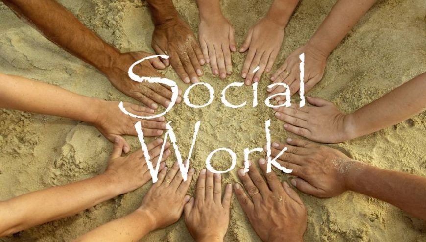 Hands in a circle  in the sand around the words "social work".