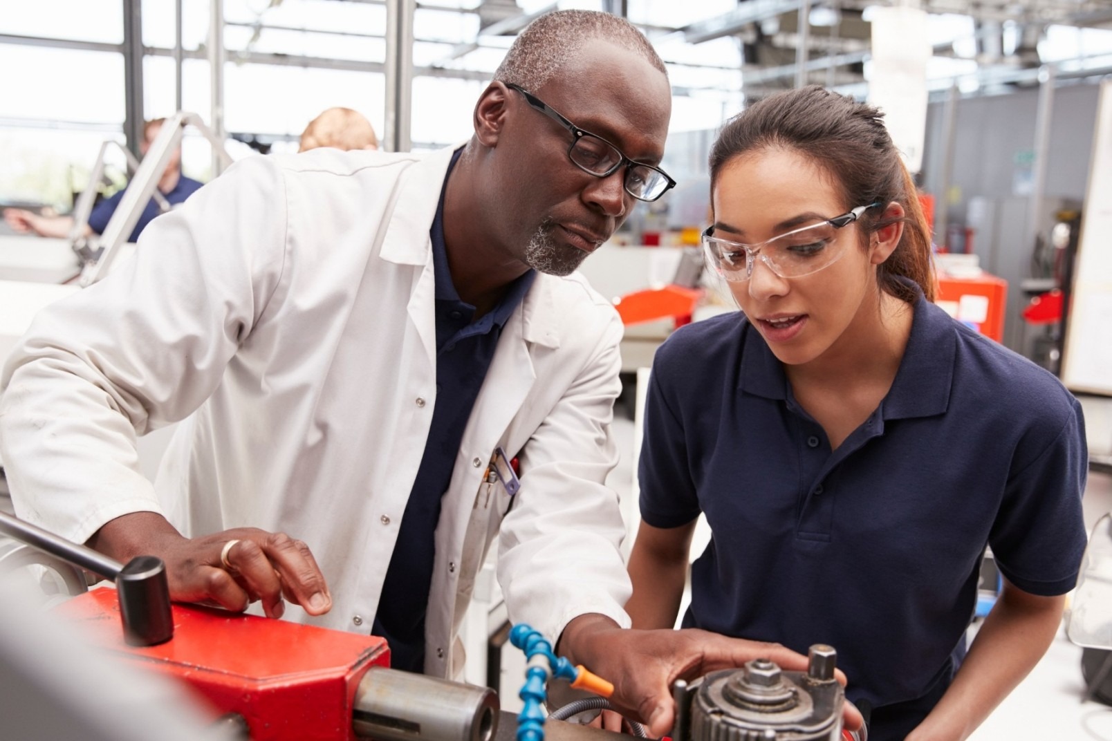 Photo of an industry person training a student for work-based learning