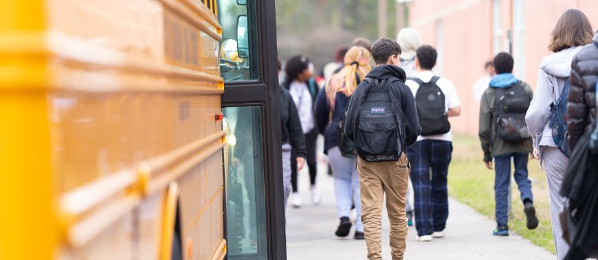 image of students walking by buses 