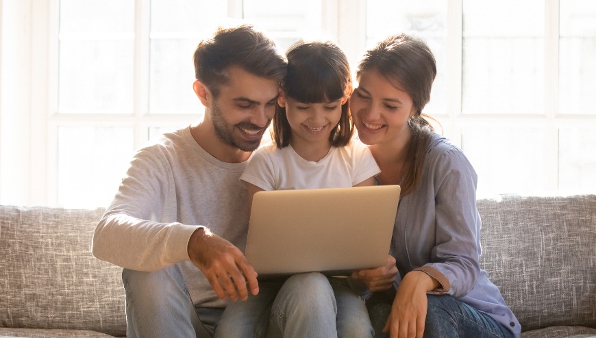 MMG Family sitting on sofa looking at laptop